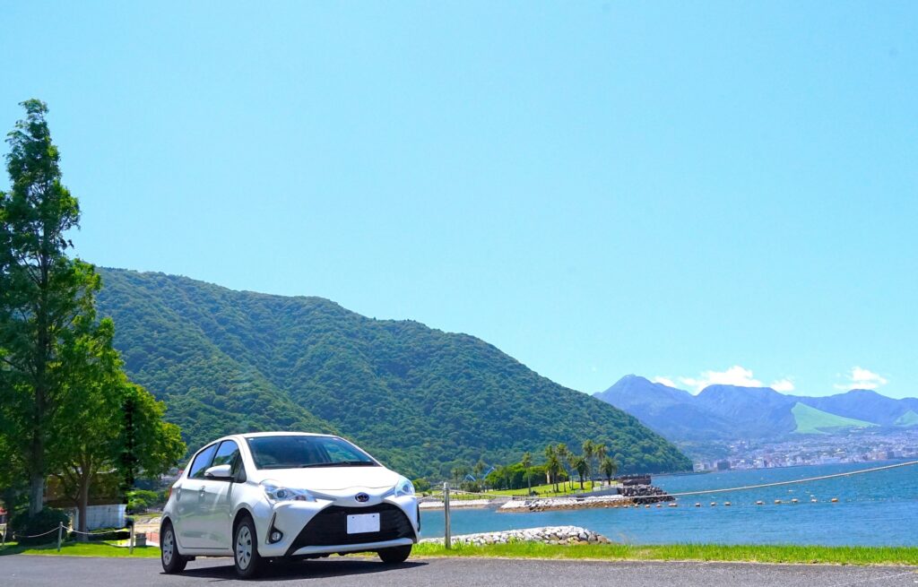 湖のほとりに停車する白い車